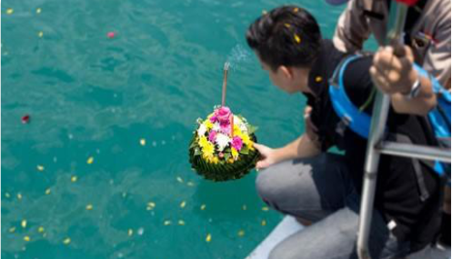 laying memorial flowers in the water off the beth ann