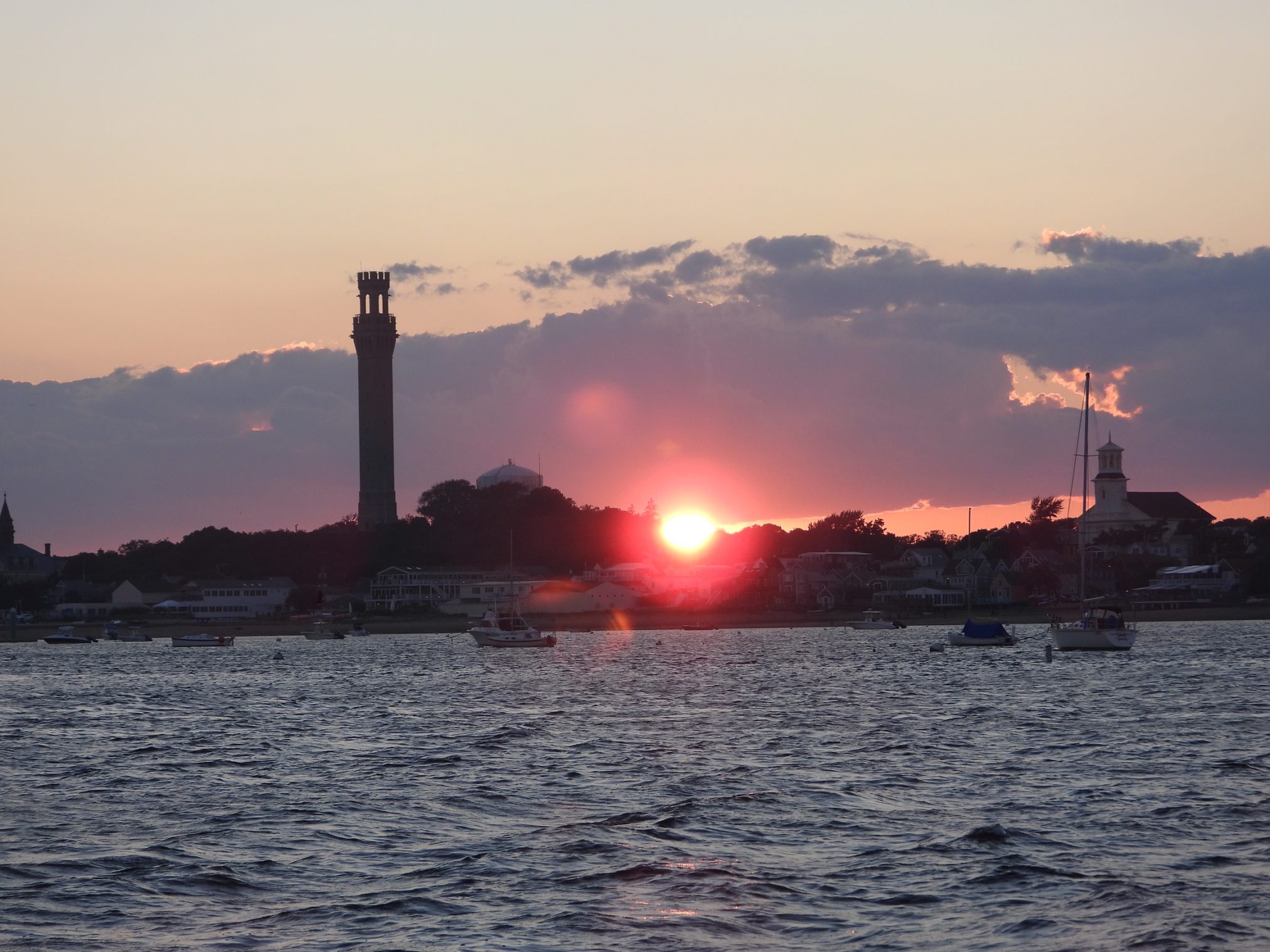 Sunset behind the Provincetown Monument viewed from the Beth Ann during an evening sunset cruise