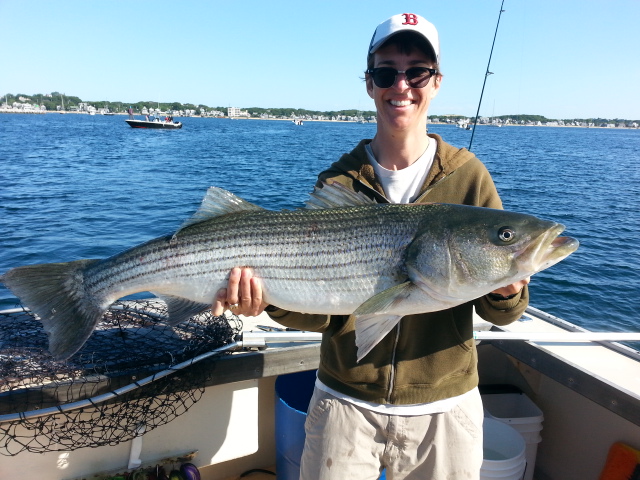Rachel Maddow holding a big striped bass caught aboard the Beth Ann of of Provincetown Harbor.